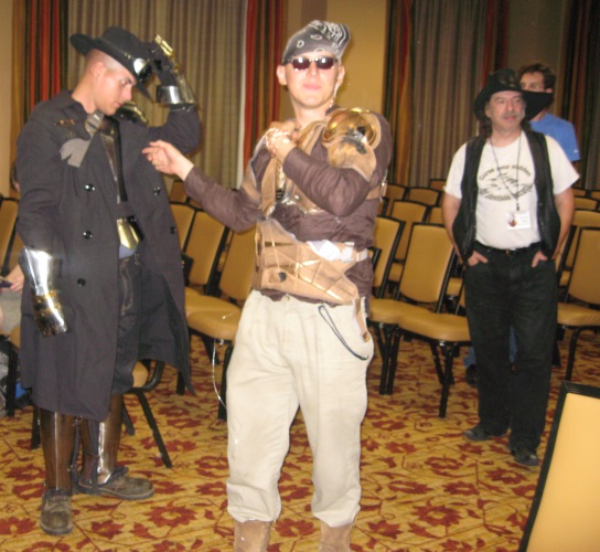 Author Steven Brust (right) accidentally photobombs steampunk costumers at the ArmadilloCon 2012