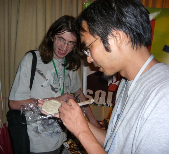David Chang writes on a clay tablet -- 'the deadest of dead media' -- at a SF fanzine Space Squid party at the ArmadilloCon 2010